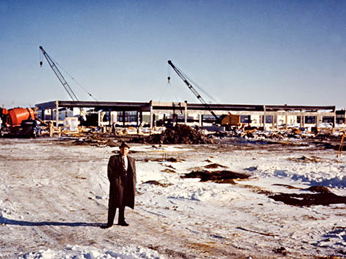 NAIT principal Jack Mitchell in front of construction of Main Campus, 1962