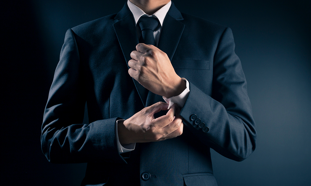 businessman in suit buttoning cuffs