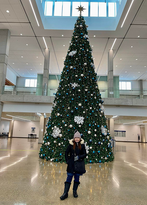 student with christmas tree in feltham centre on NAIT campus