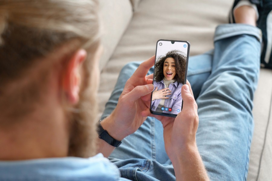 young man connecting with friend over video call