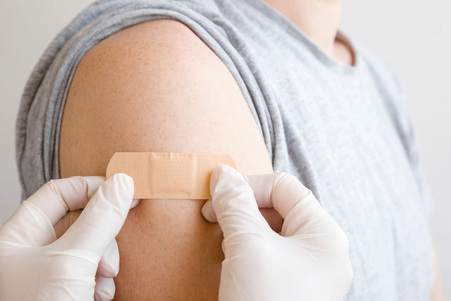 band aid being applied to vaccination site