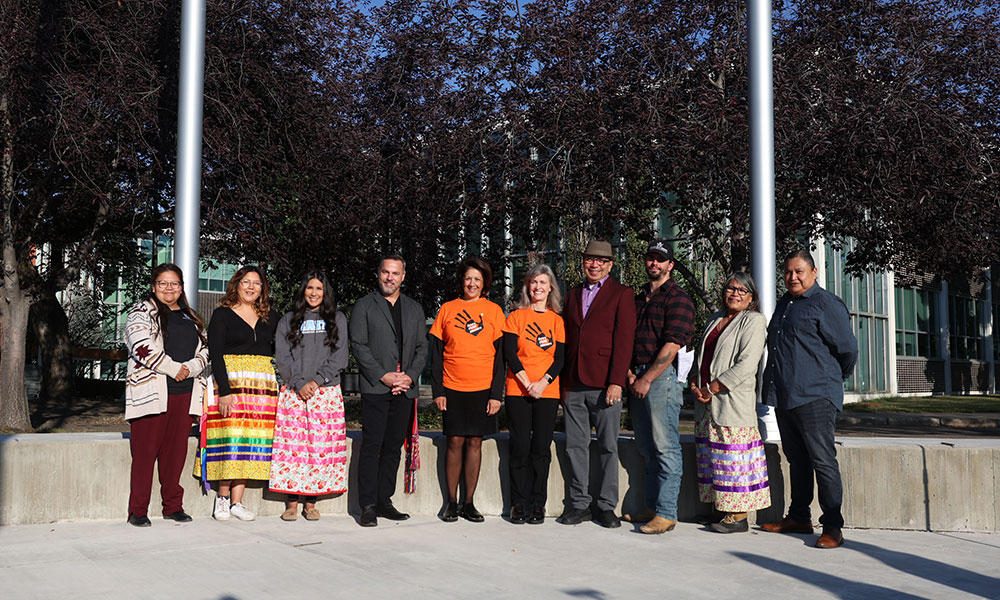 Groupl photo at NAIT's Flagpole Plaza, Nîsôhkamâtotân Centre, executive and guestsincluding staff from the