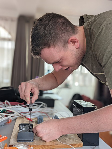 NAIT alternative energy student Logan holroyd wires a charge controller during training in ayacucho peru