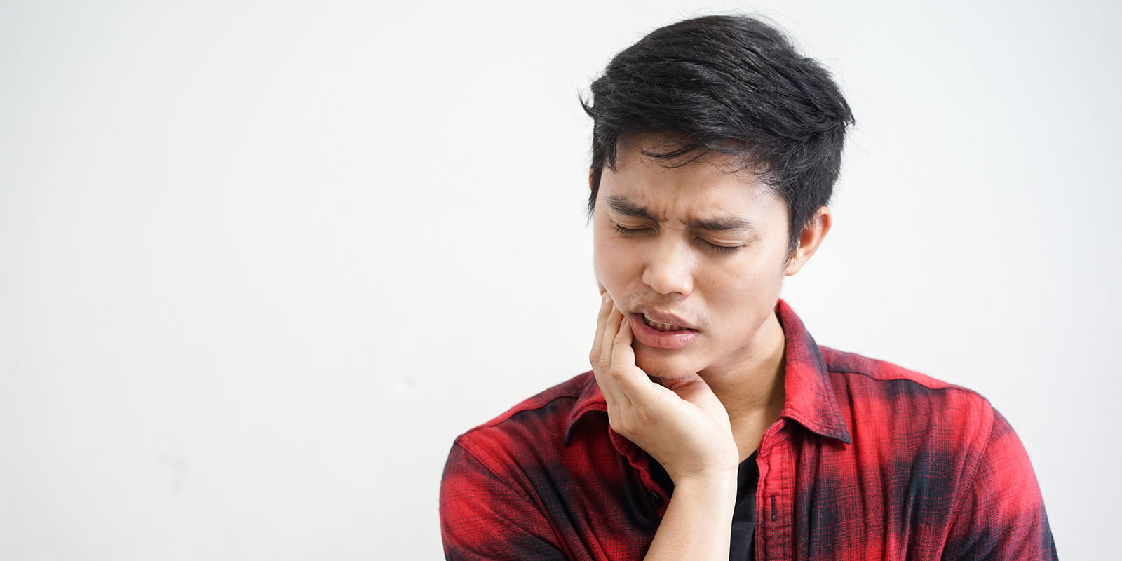 man holding sore jaw