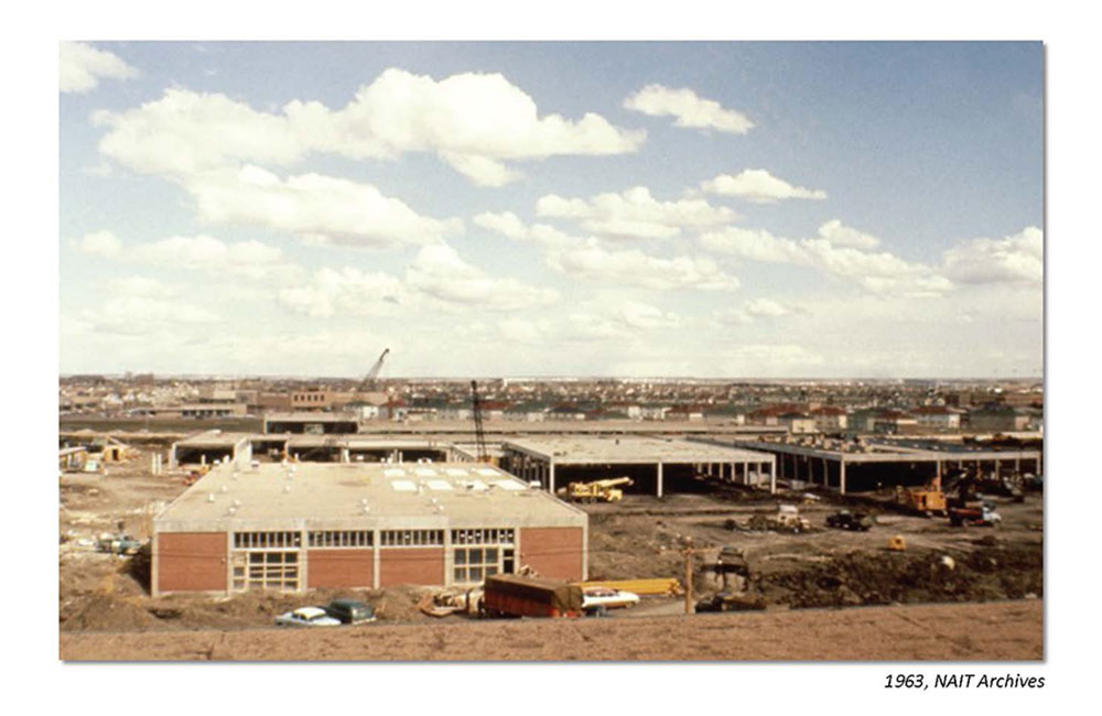 1963 photo of NAIT campus under construction with cranes, vehicles, and unfinished buildings.