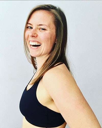 Side profile of a person wearing a black sports bra against a neutral background.