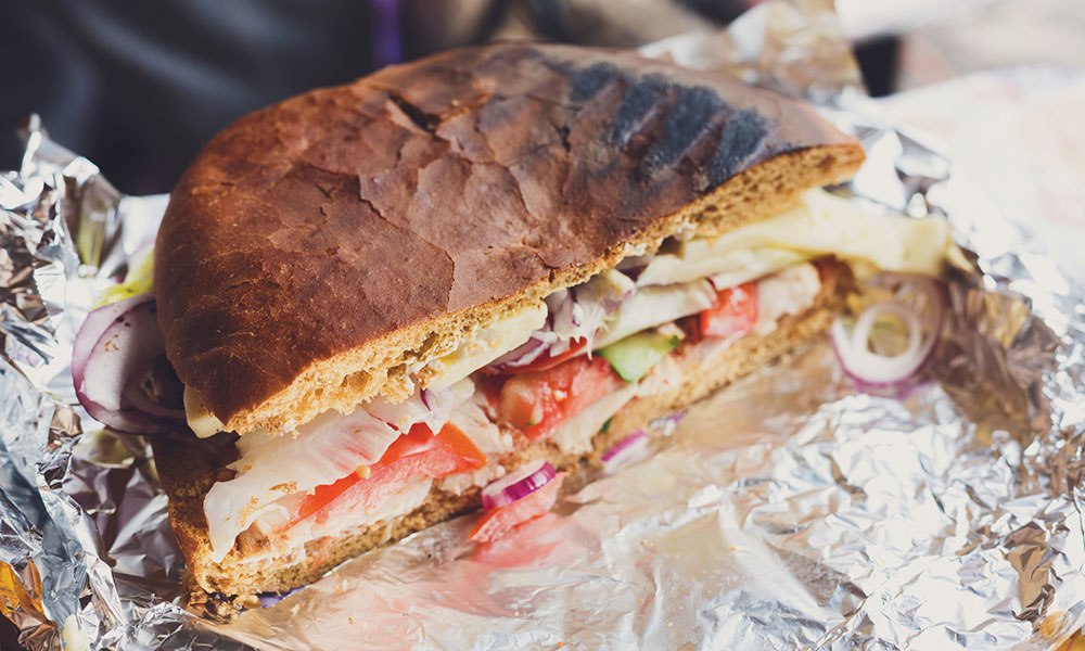 panini style sandwich sitting on foil wrapper