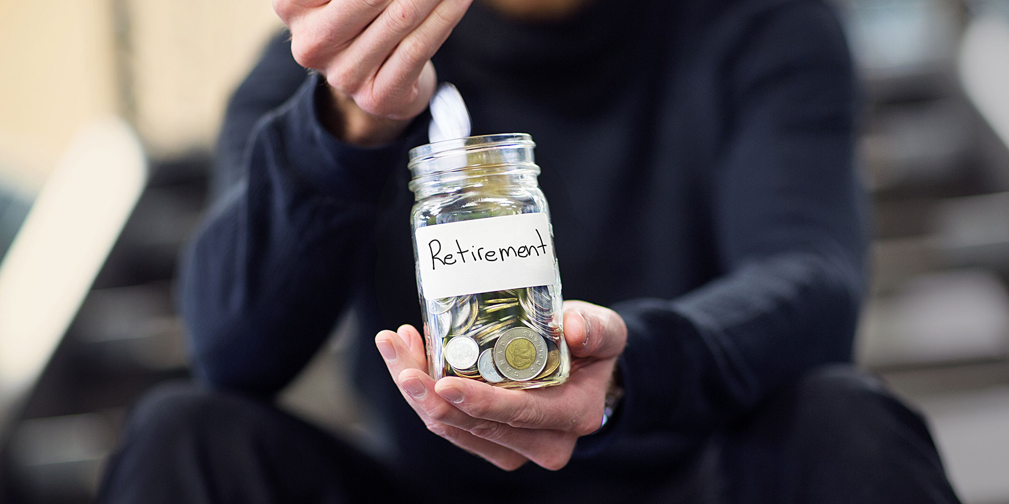 man dropping coins into jar labelled RRSP