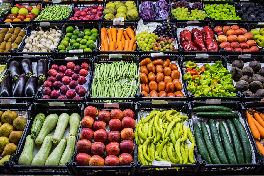 vegetables displayed in black crates at farmers market